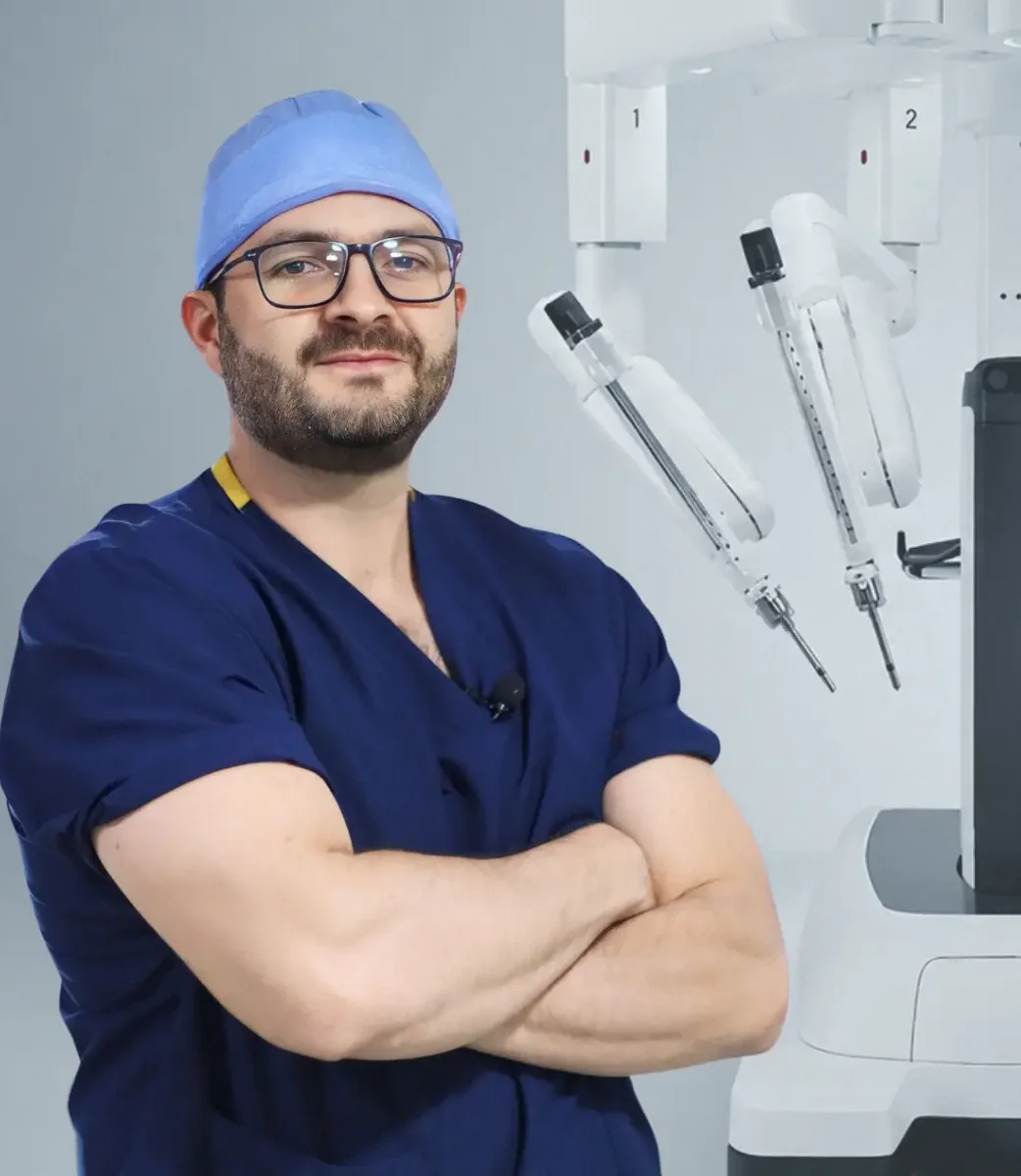 Dr. Felipe Bernal, cirujano bariátrico en Bogotá, con los brazos cruzados junto al robot quirúrgico Da Vinci Xi